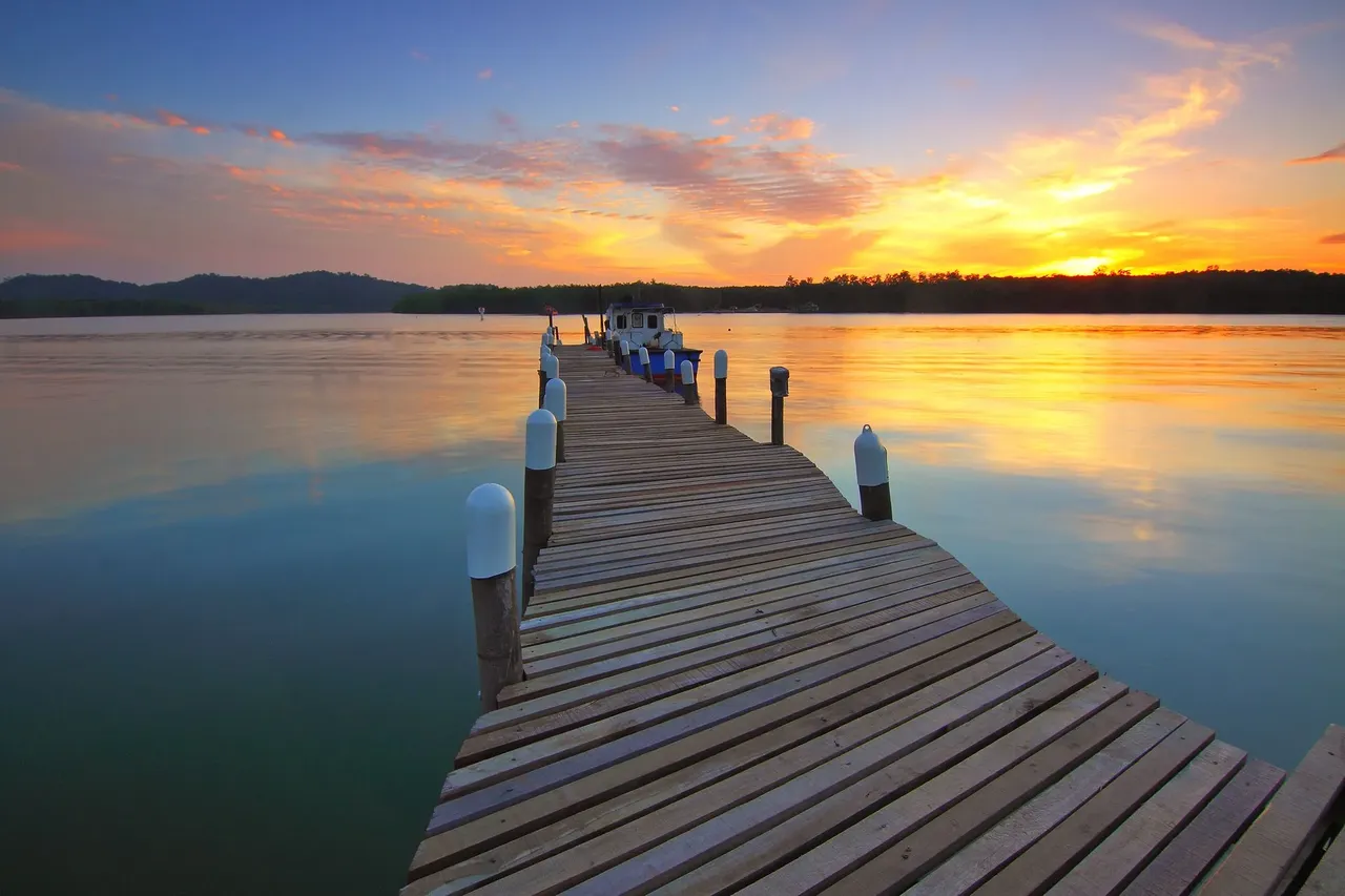 Wooden dock stretching over calm lake water at sunset, the kind of waterfront setting found around Lake Houston